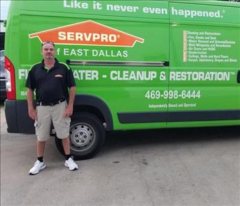 Male employee, Russell Crew Chief taking picture next to SERVPRO green truck